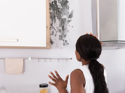 Une dame constate l'apparition d'humidité dans sa maison